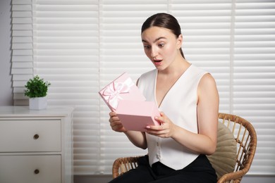 Photo of Dreams come true. Excited woman with gift at home