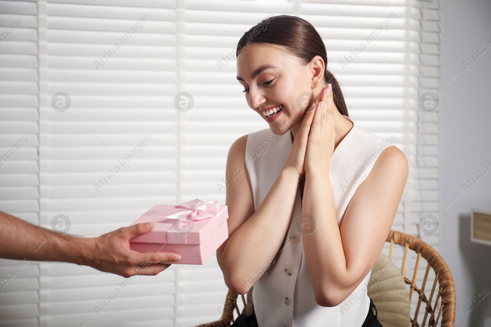 Dreams come true. Man surprising woman with gift at home, closeup. Space for text Photo of Dreams come true. Man surprising woman with gift at home, closeup. Space for text