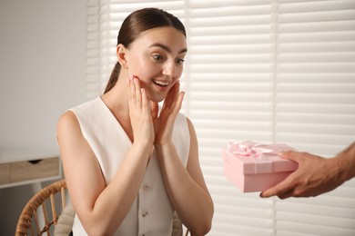 Photo of Dreams come true. Man surprising woman with gift at home, closeup. Space for text