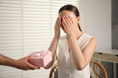 Photo of Dreams come true. Man surprising woman with gift at home, closeup. Space for text