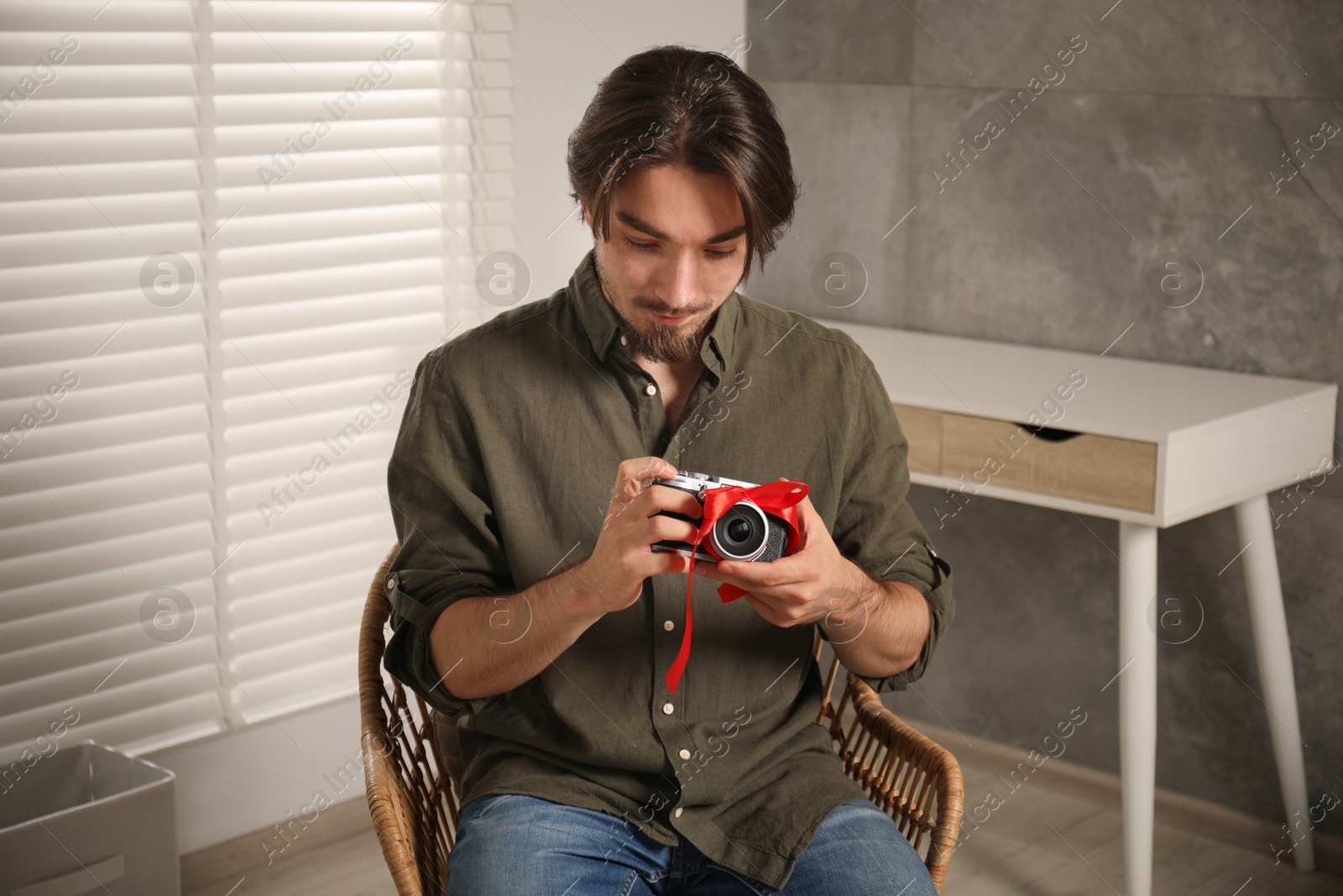 Dreams come true. Man with new gifted camera at home Photo of Dreams come true. Man with new gifted camera at home