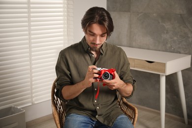 Photo of Dreams come true. Man with new gifted camera at home