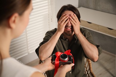 Photo of Dreams come true. woman gifting man camera at home, closeup
