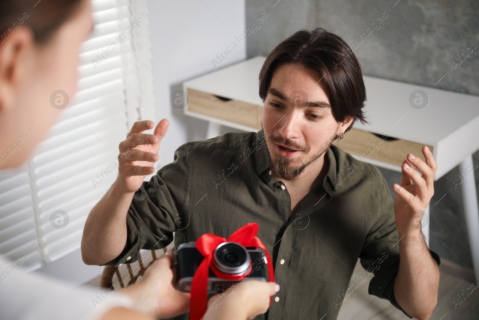 Photo of Dreams come true. woman gifting man camera at home, closeup