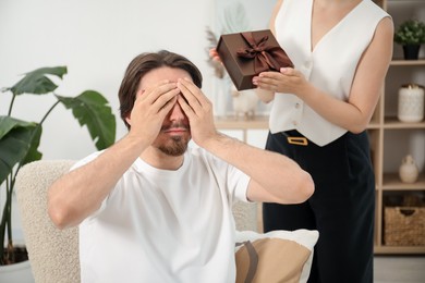 Photo of Dreams come true. Woman giving man gift box at home, closeup