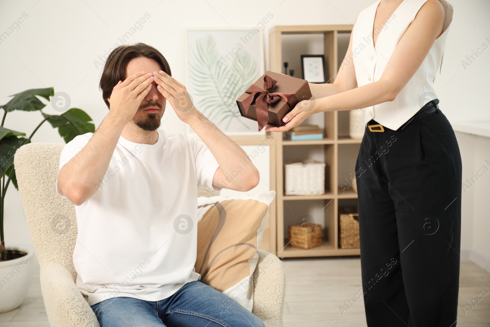 Dreams come true. Woman giving man gift box at home, closeup Photo of Dreams come true. Woman giving man gift box at home, closeup