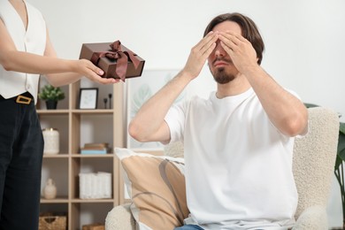 Photo of Dreams come true. Woman giving man gift box at home, closeup