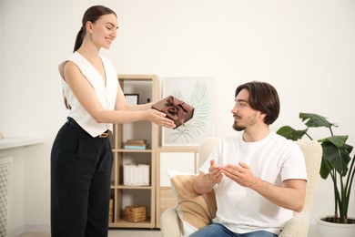 Photo of Dreams come true. Woman giving man gift box at home