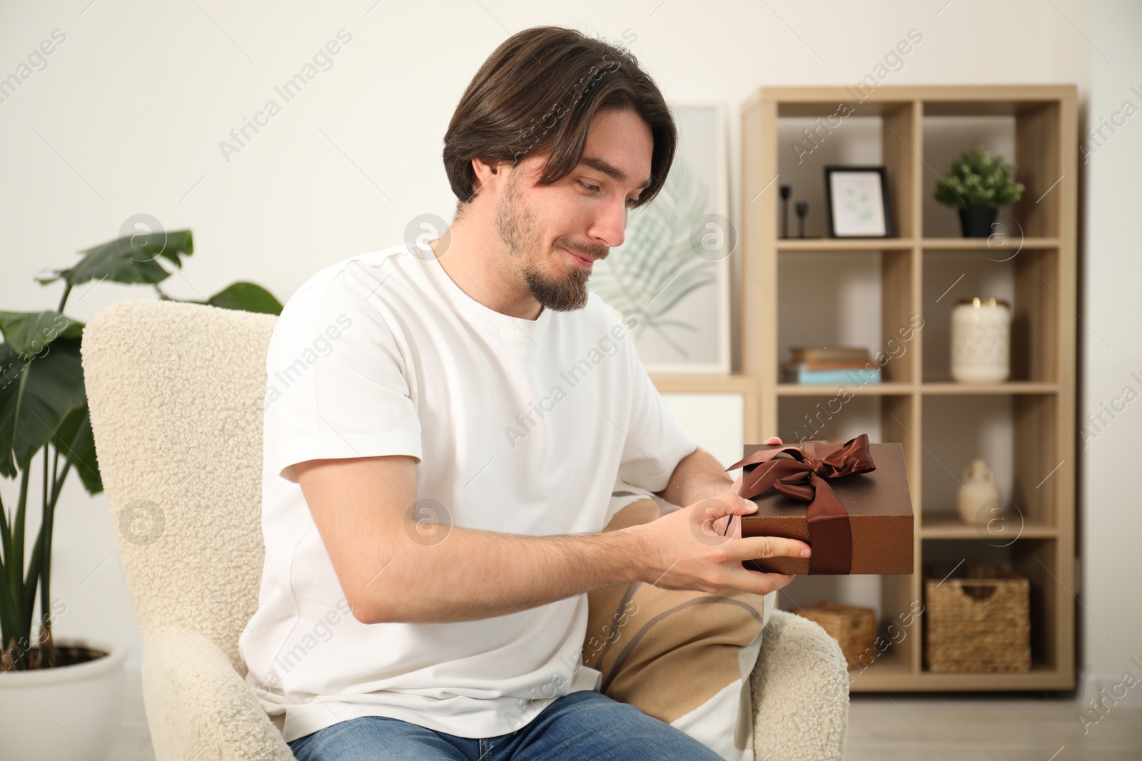 Dreams come true. Man with gift at home Photo of Dreams come true. Man with gift at home
