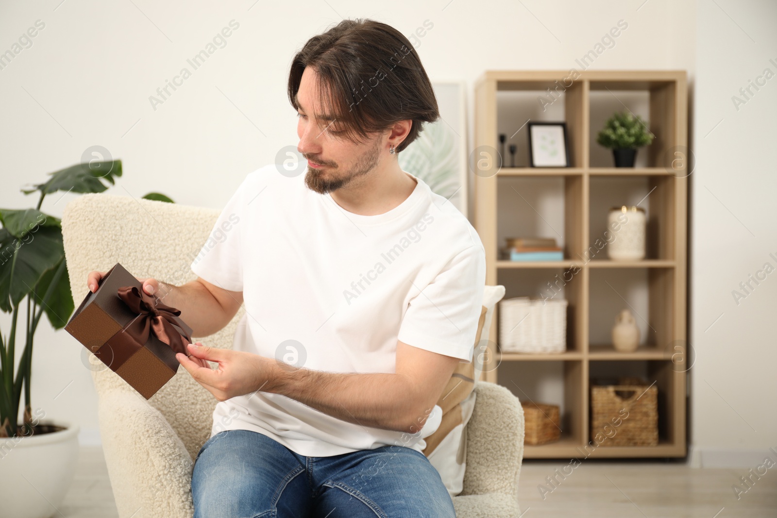 Dreams come true. Man with gift at home Photo of Dreams come true. Man with gift at home