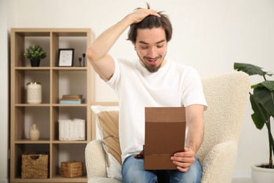 Photo of Dreams come true. Man opening gift at home