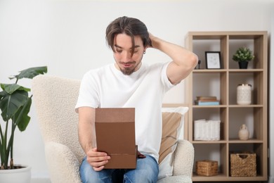 Photo of Dreams come true. Man opening gift at home