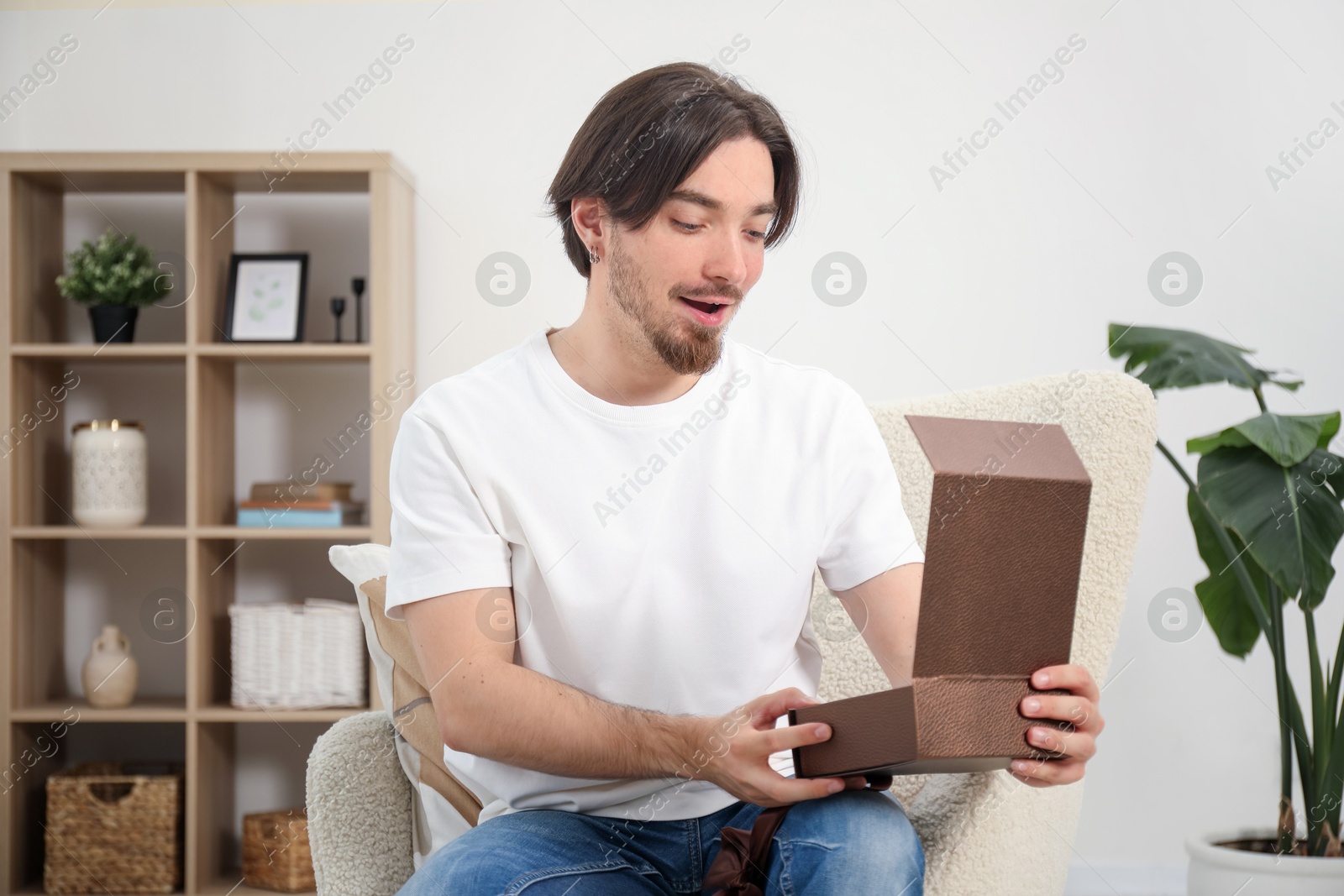 Dreams come true. Man opening gift at home Photo of Dreams come true. Man opening gift at home