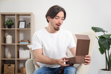 Photo of Dreams come true. Man opening gift at home