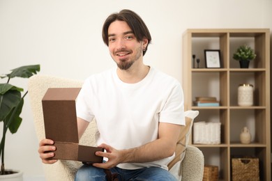 Photo of Dreams come true. Man opening gift at home