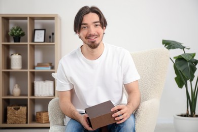 Photo of Dreams come true. Man opening gift at home