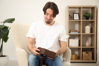 Photo of Dreams come true. Man opening gift at home