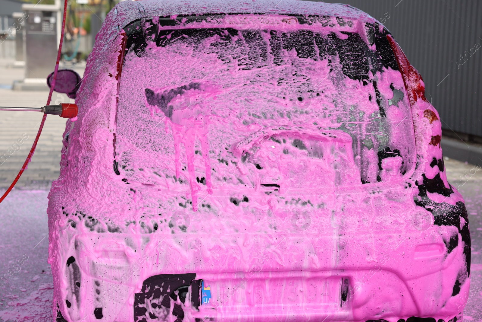 Auto covered with cleaning foam at outdoor car wash, closeup Photo of Auto covered with cleaning foam at outdoor car wash, closeup