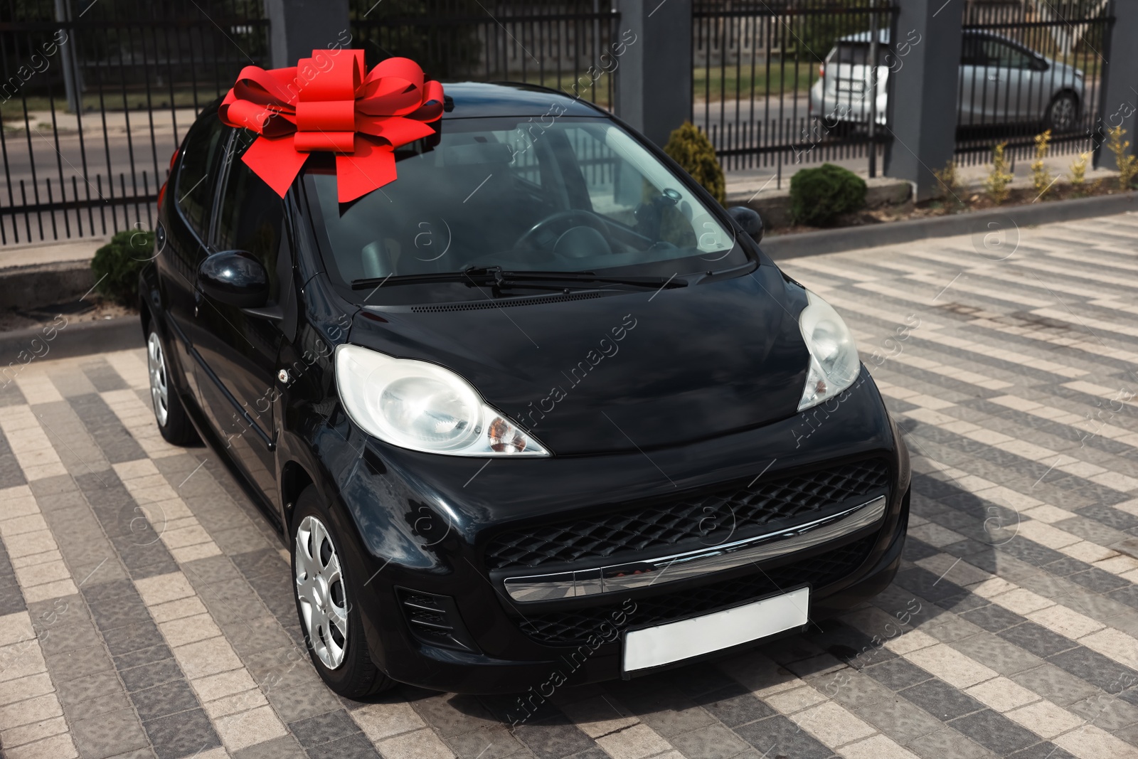Dreams come true. New auto with big red bow outdoors Photo of Dreams come true. New auto with big red bow outdoors