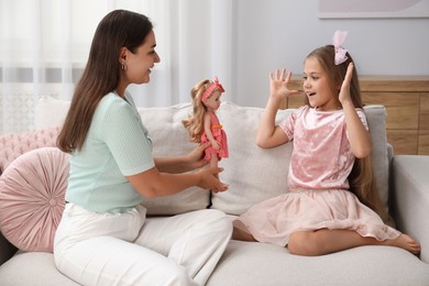 Photo of Dreams come true. Mother giving doll to her daughter at home