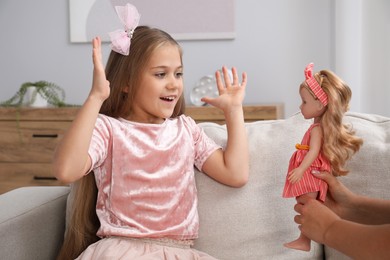 Photo of Dreams come true. Mother giving doll to her daughter at home, closeup