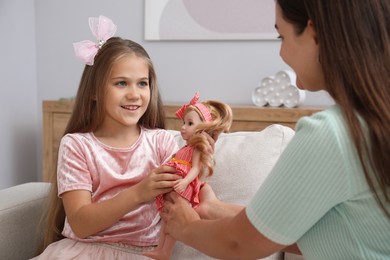 Photo of Dreams come true. Mother giving doll to her daughter at home