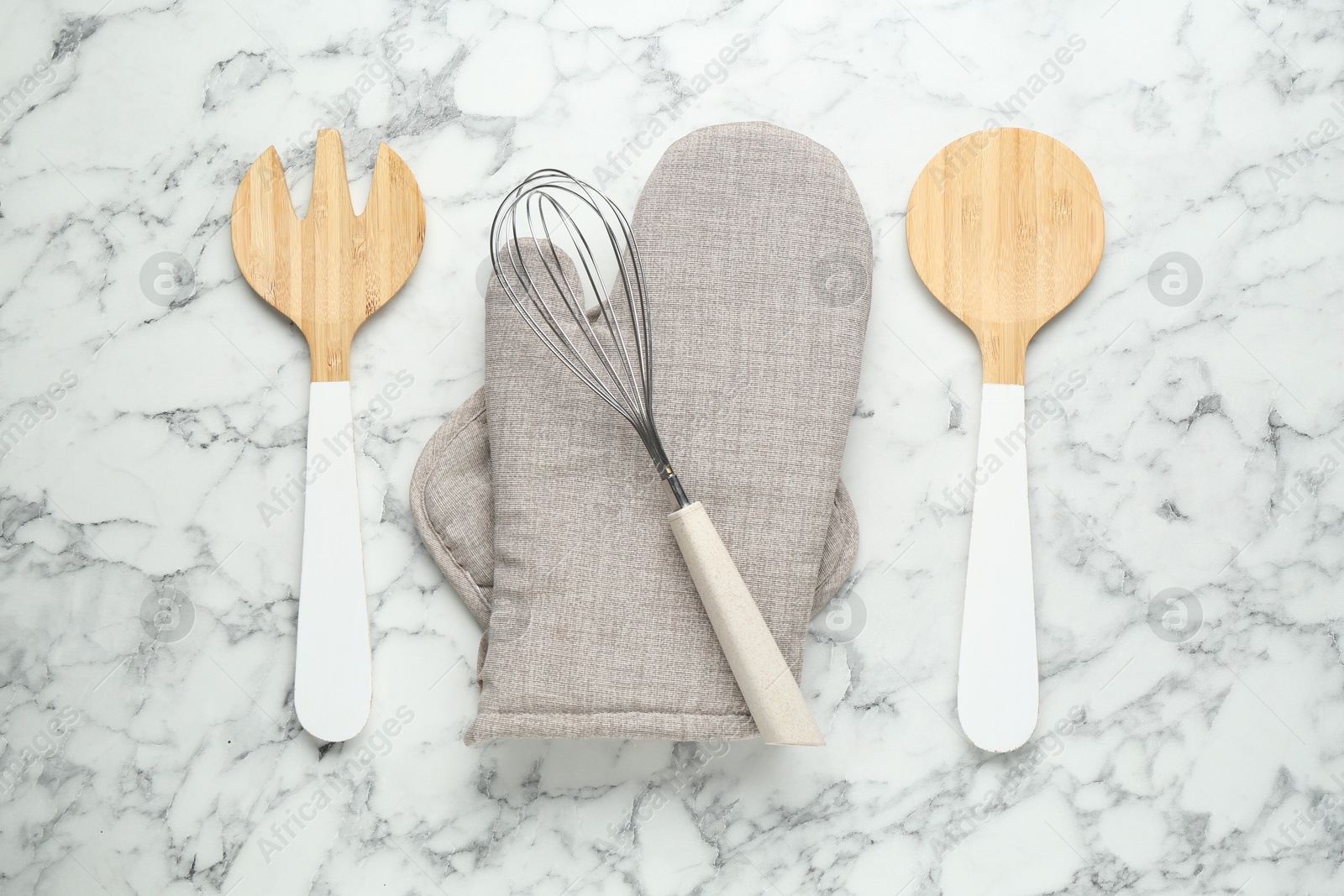 Oven glove, potholder and other kitchen utensils on white marble table, flat lay Photo of Oven glove, potholder and other kitchen utensils on white marble table, flat lay