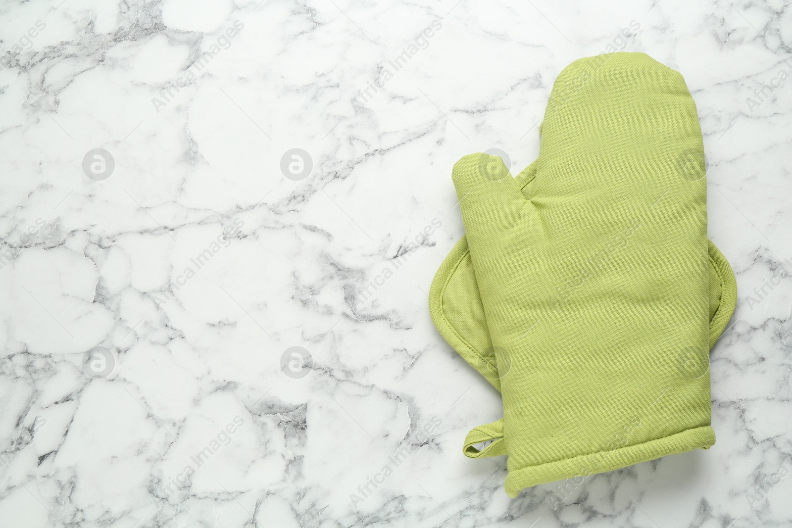 Oven glove and potholder on white marble table, top view. Space for text Photo of Oven glove and potholder on white marble table, top view. Space for text