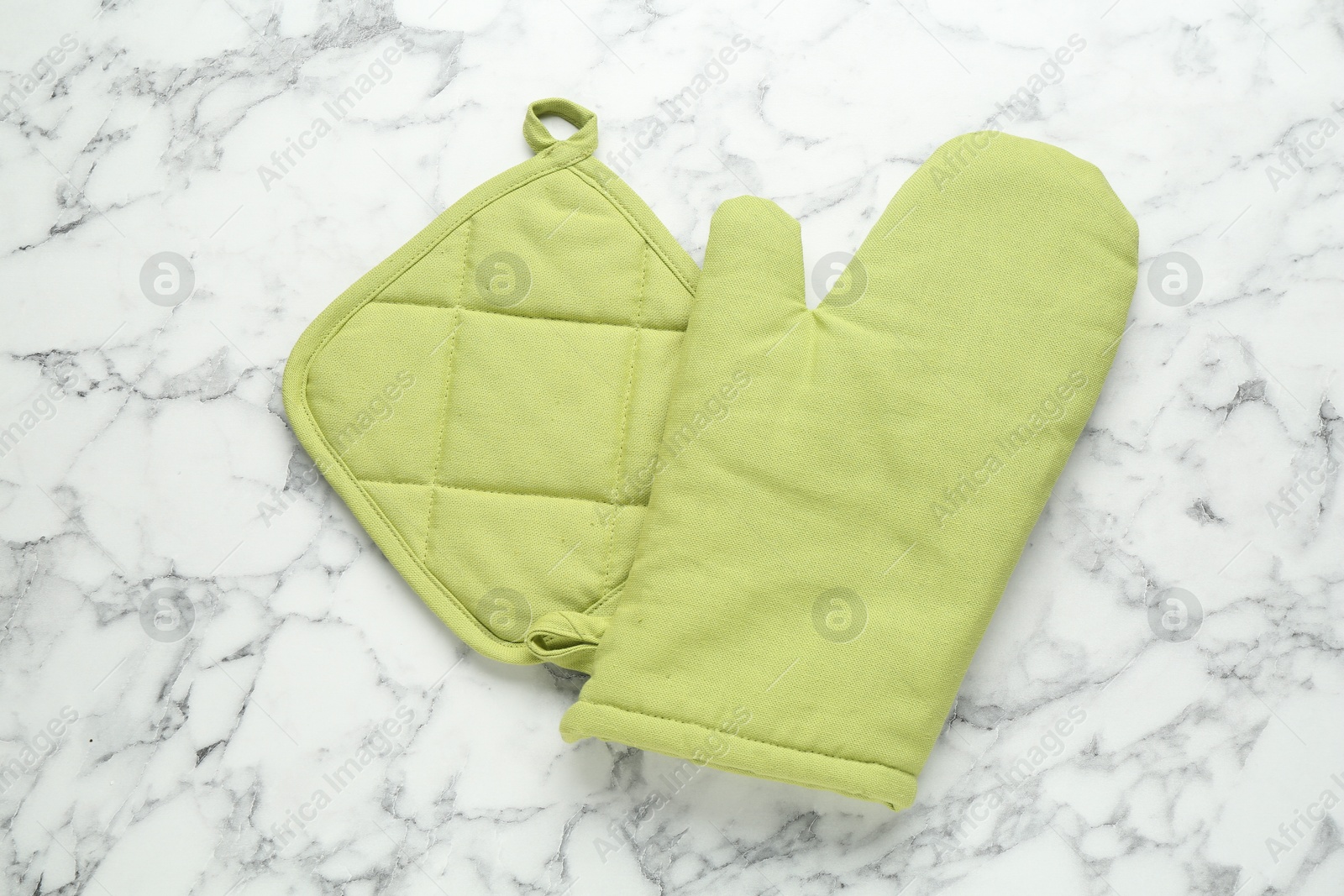 Oven glove and potholder on white marble table, flat lay Photo of Oven glove and potholder on white marble table, flat lay