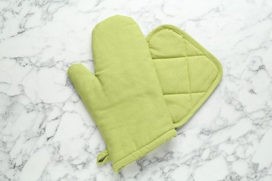 Photo of Oven glove and potholder on white marble table, flat lay