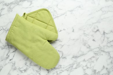 Photo of Oven glove and potholder on white marble table, flat lay. Space for text
