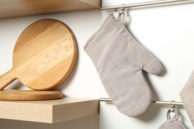 Photo of Oven glove hanging on metal rack in kitchen