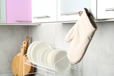 Photo of Oven glove hanging on handle of cabinet in kitchen