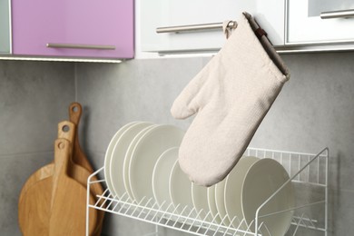 Photo of Oven glove hanging on handle of cabinet in kitchen