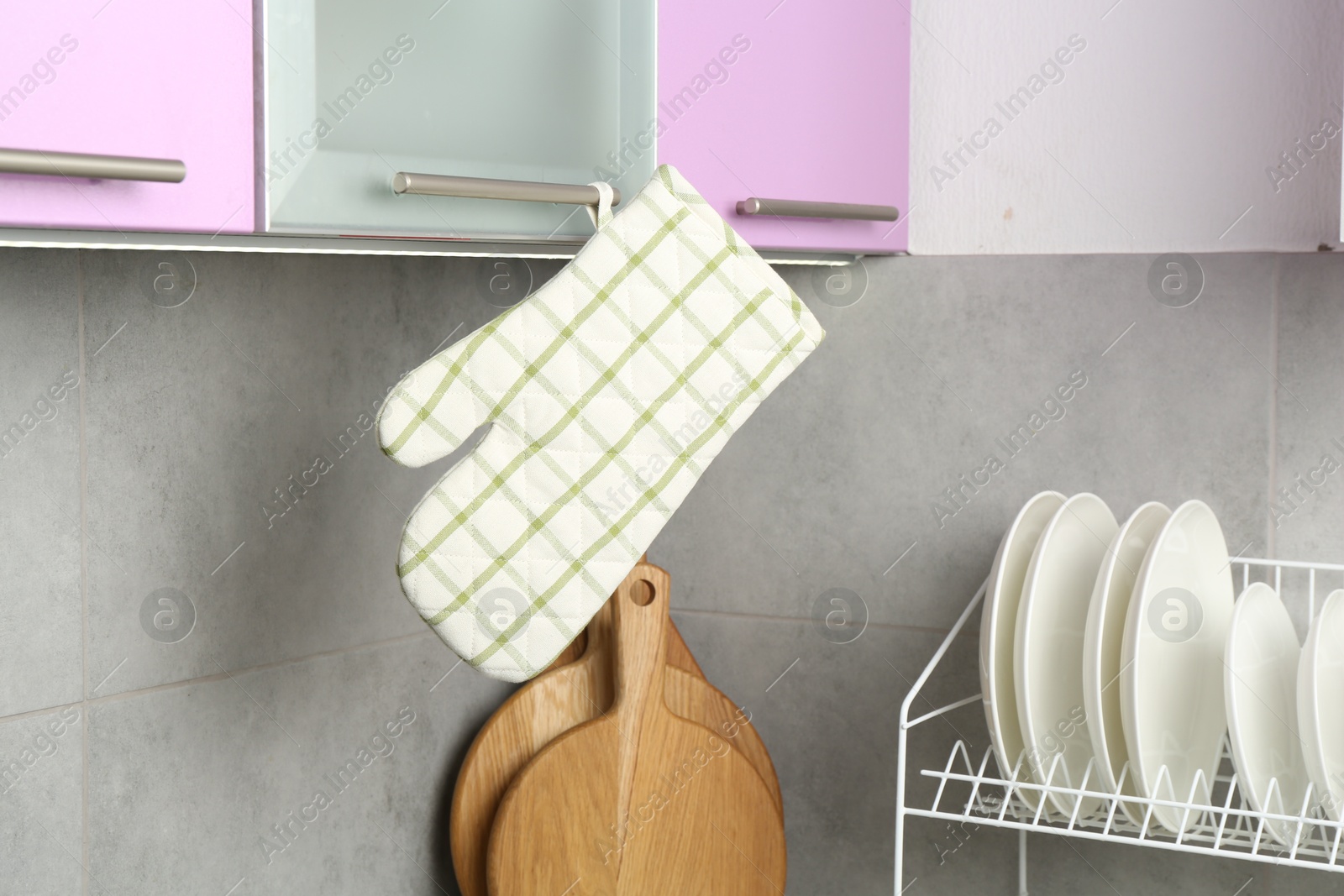 Photo of Oven glove hanging on handle of cabinet in kitchen