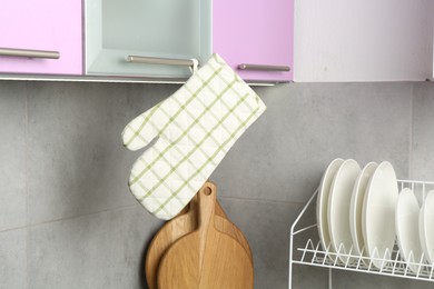 Photo of Oven glove hanging on handle of cabinet in kitchen