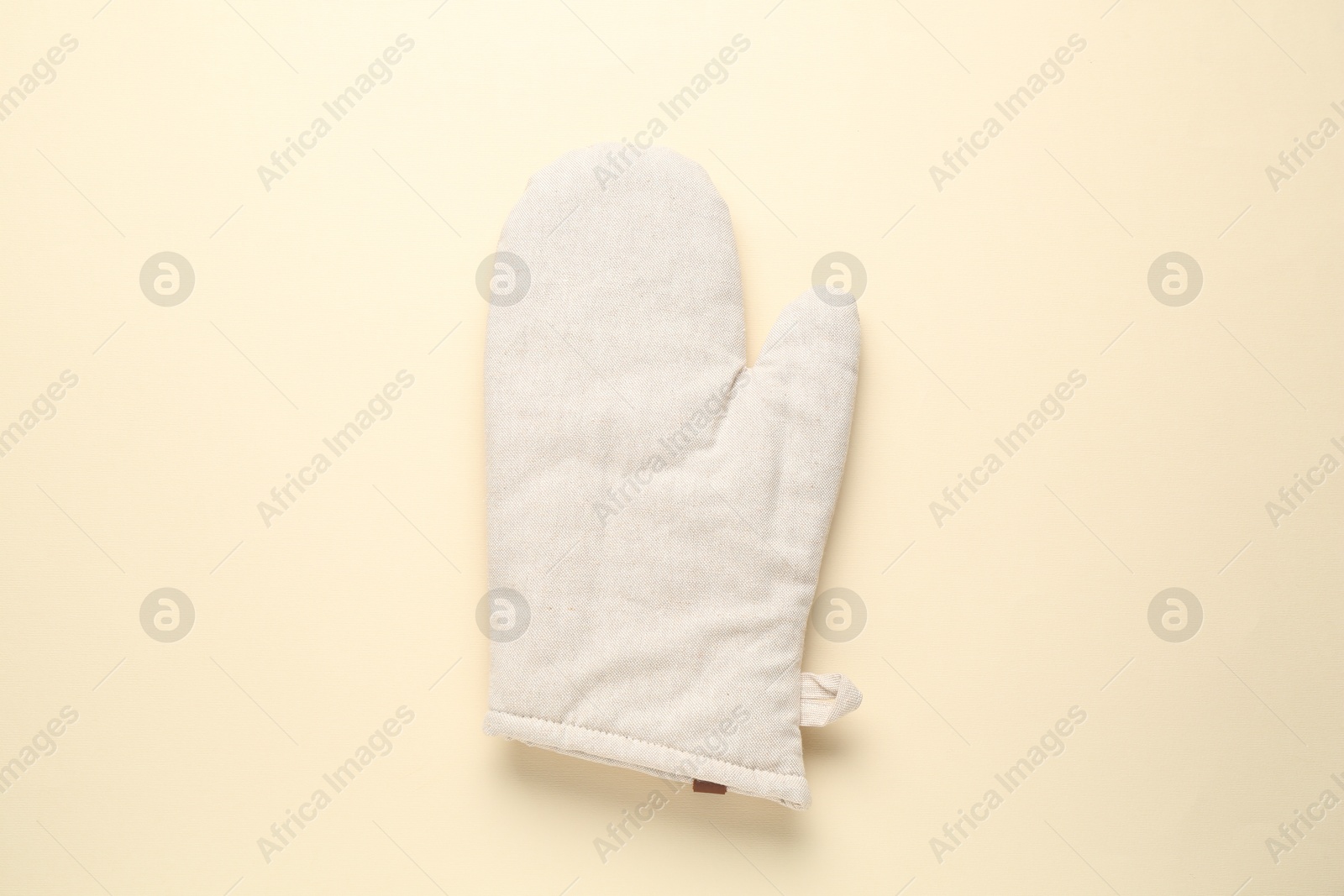 Photo of One oven glove on beige background, top view