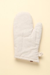 Photo of One oven glove on beige background, top view