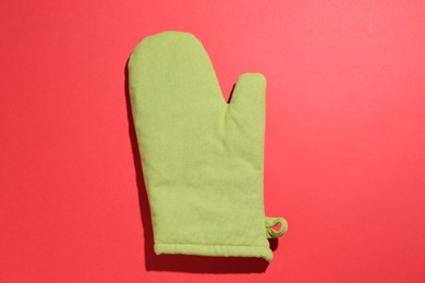 Photo of One oven glove on red background, top view