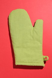 Photo of One oven glove on red background, top view