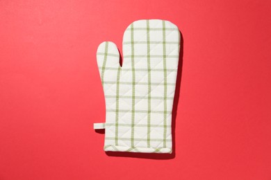 Photo of One oven glove on red background, top view