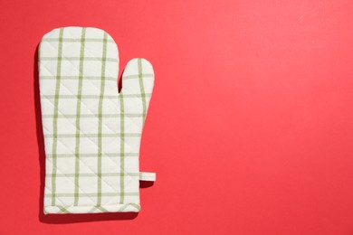 Photo of One oven glove on red background, top view. Space for text