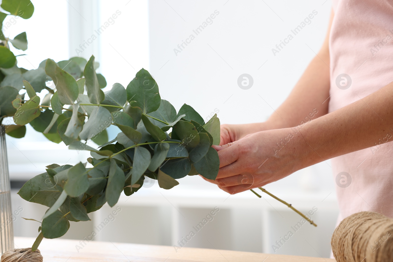 Florist making beautiful bouquet of eucalyptus branches at table in flower shop, closeup Photo of Florist making beautiful bouquet of eucalyptus branches at table in flower shop, closeup