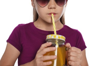 Photo of Little girl drinking juice through straw on white background, closeup