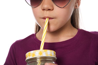 Photo of Little girl drinking refreshing drink through straw on white background, closeup