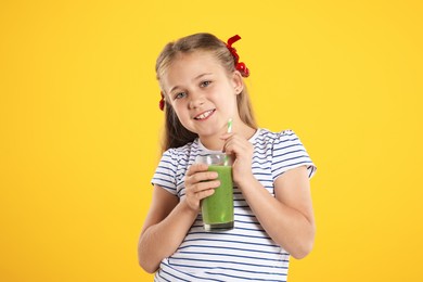 Photo of Little girl with juice and drinking straw on orange background