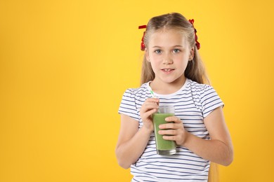 Photo of Little girl with juice and drinking straw on orange background, space for text