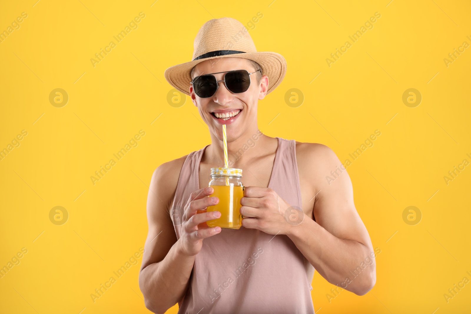 Photo of Man with juice and drinking straw on orange background