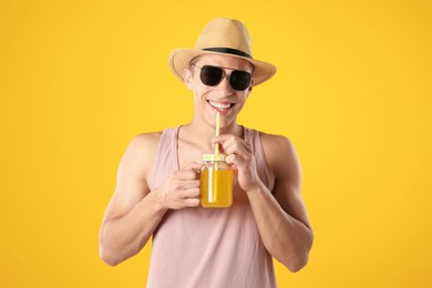 Photo of Man with juice and drinking straw on orange background