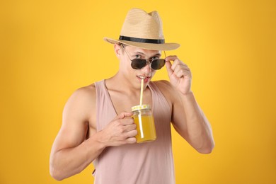 Photo of Man with juice and drinking straw on orange background
